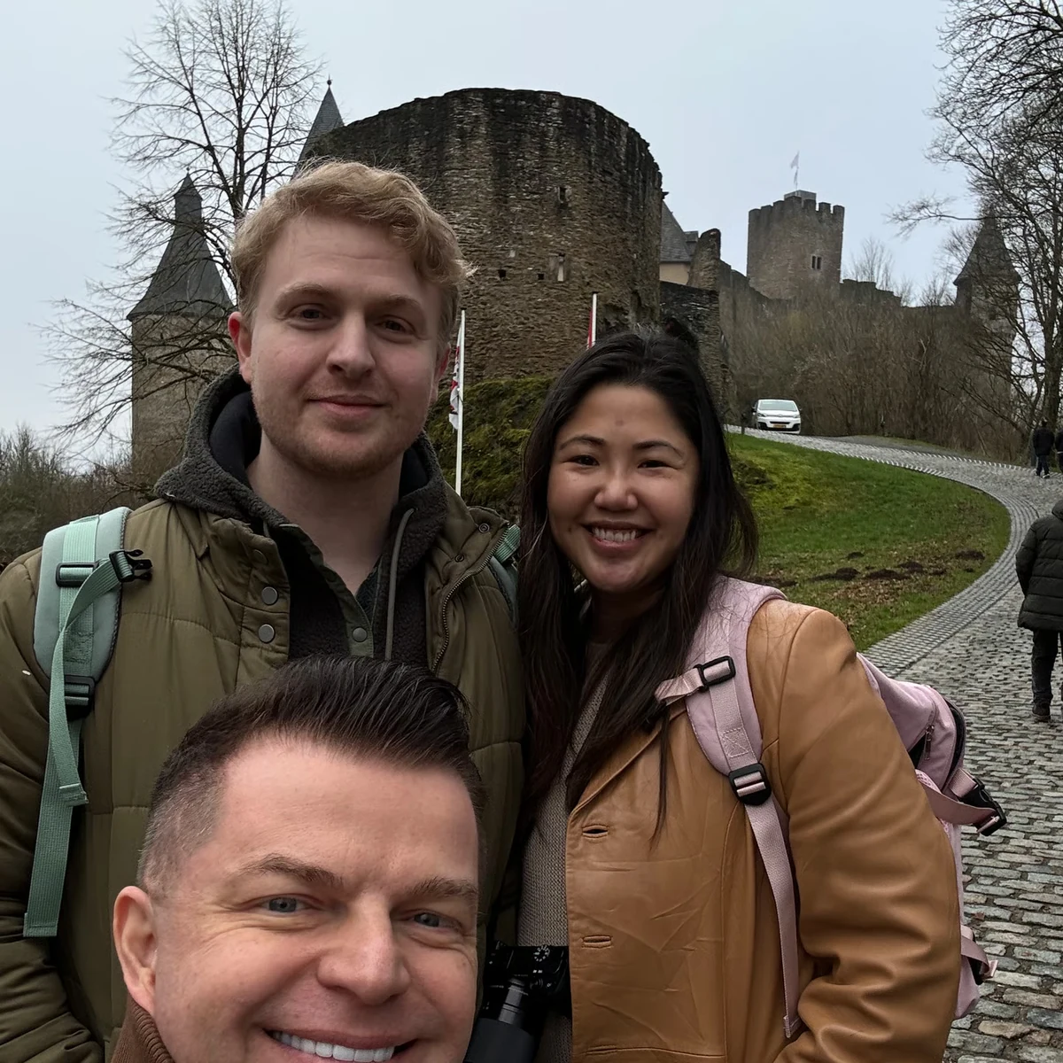 Private tour guests smiling with a castle ruin behind them