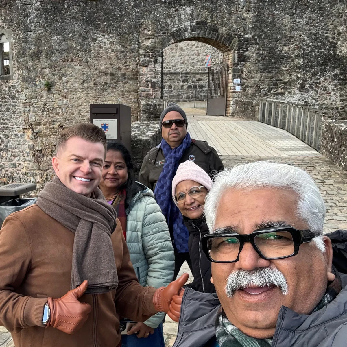 Private tour guests with their guide on a stone castle bridge