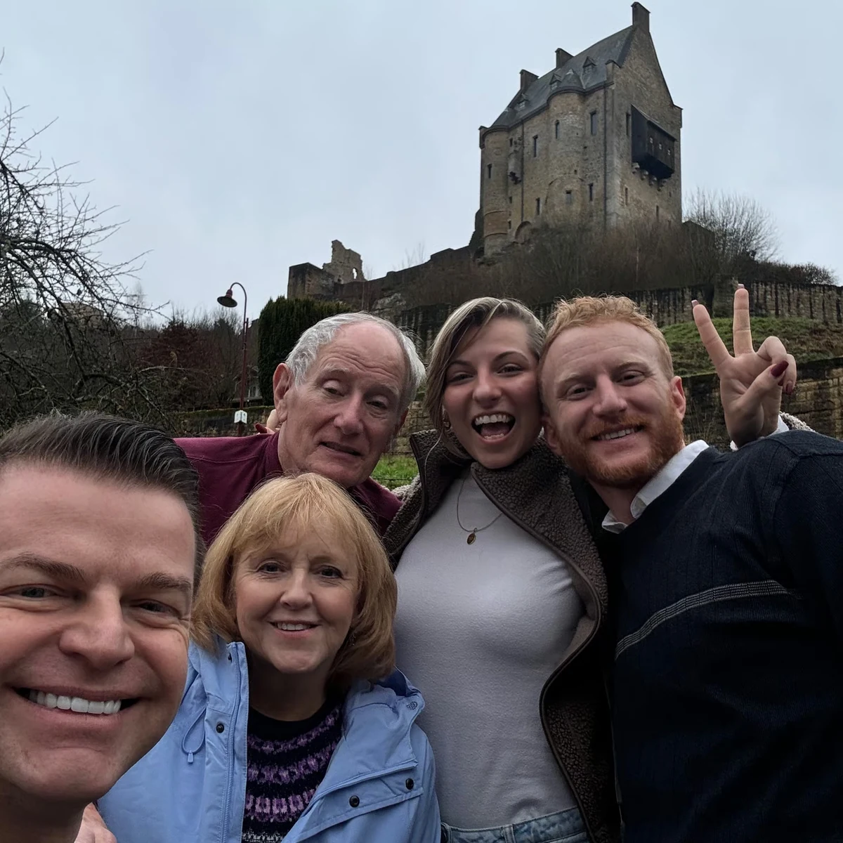 Private tour guests smiling below a medieval castle tower