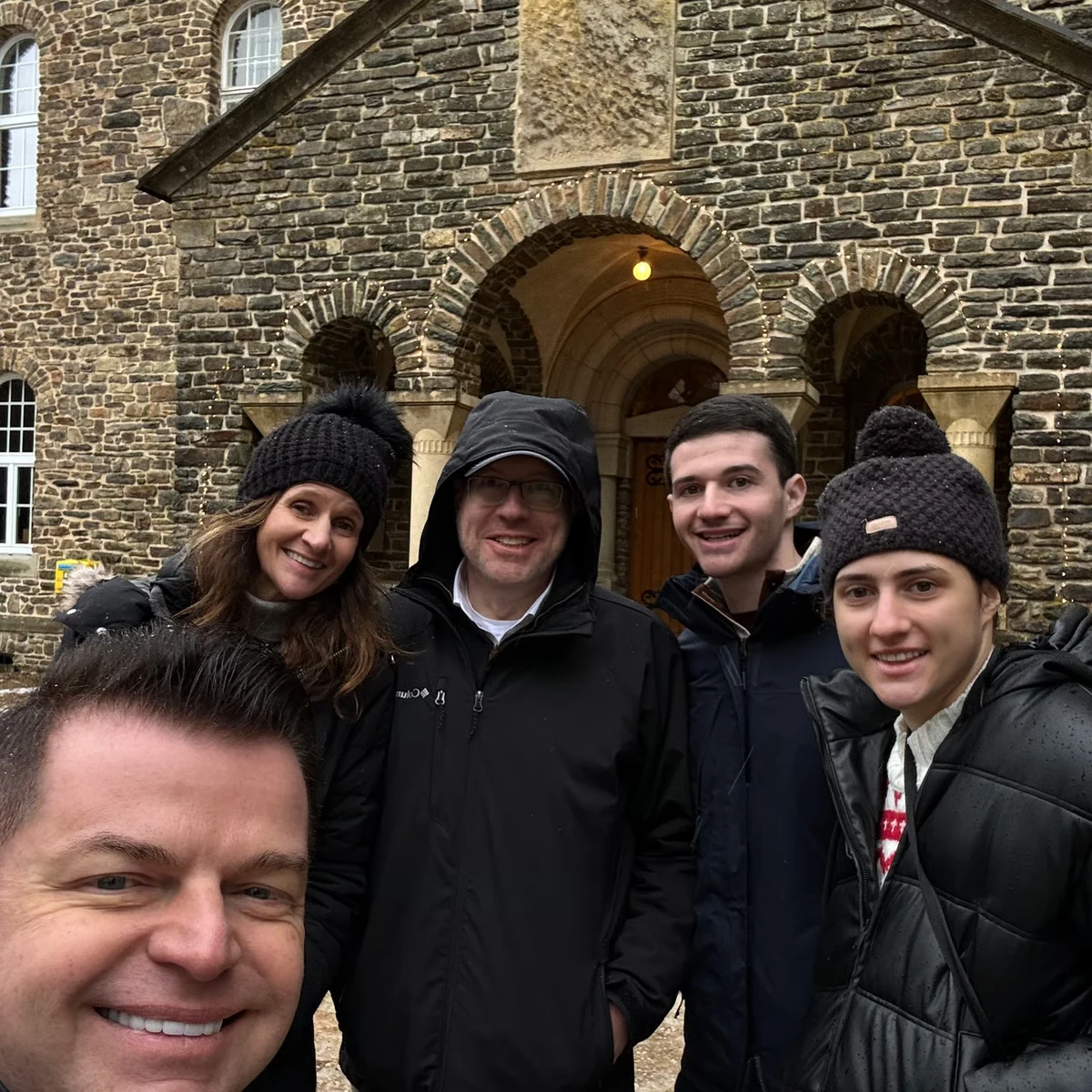 Young travellers and their guide outside a medieval stone gate
