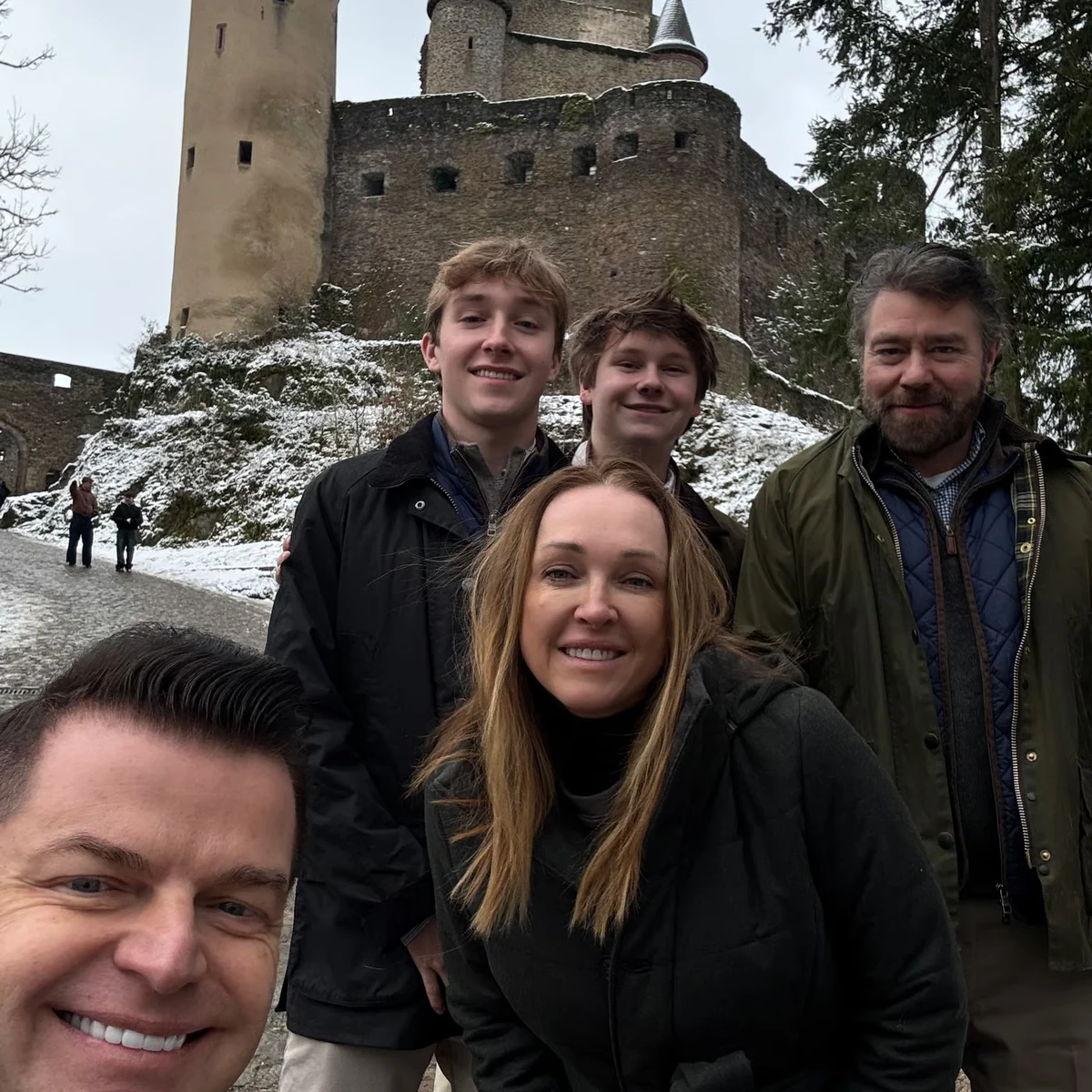 Winter private tour guests smiling below a Luxembourg castle
